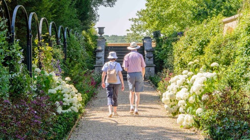Couple walking down in the Victorian Border in Ickworrth's Italianate garden